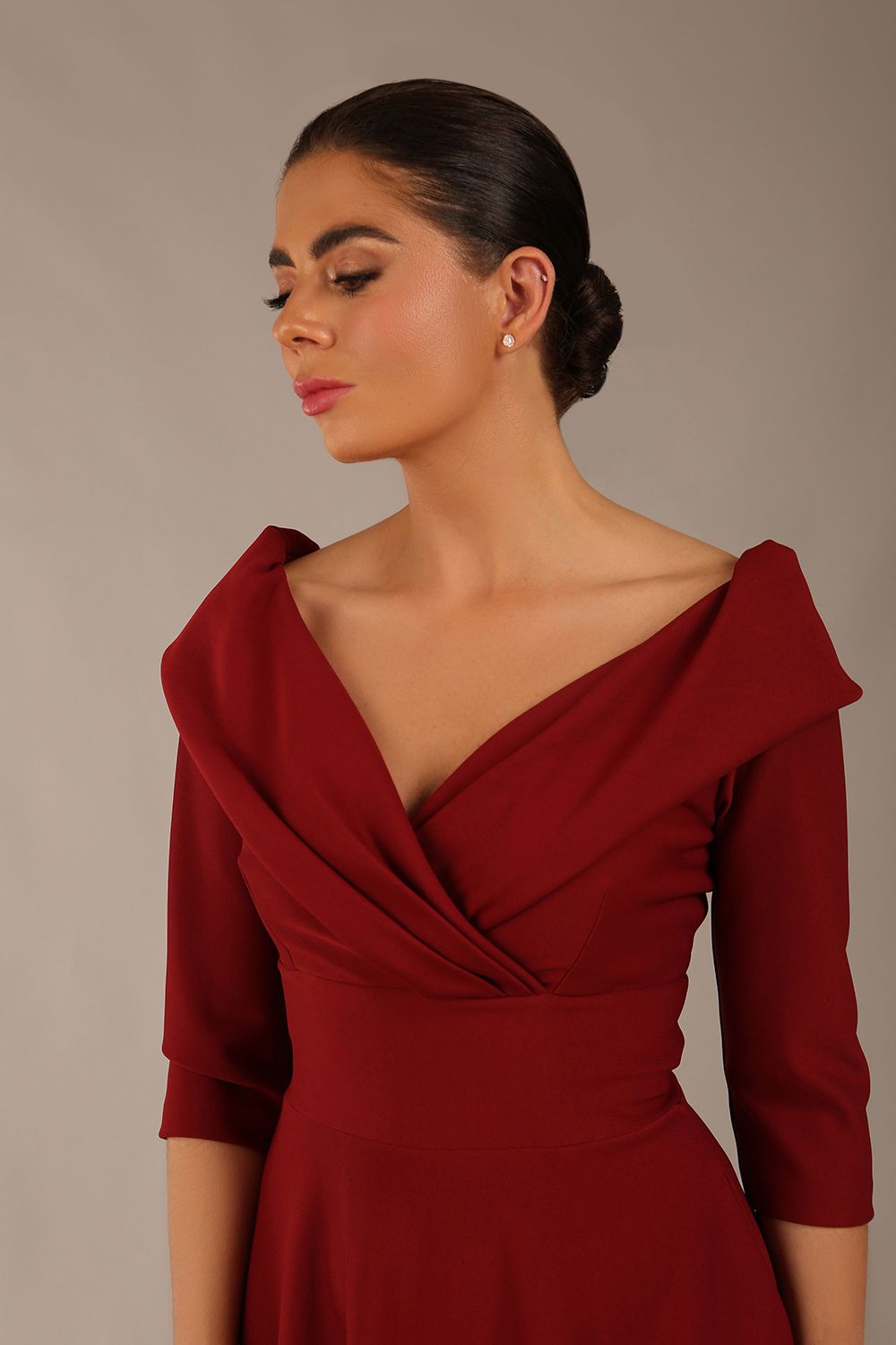 brunette model is wearing a diva catwalk Fabienne sleeved A-line Dress with pockets v neckline knee length wide waistband fold over v neckline in burgundy colour front image close up