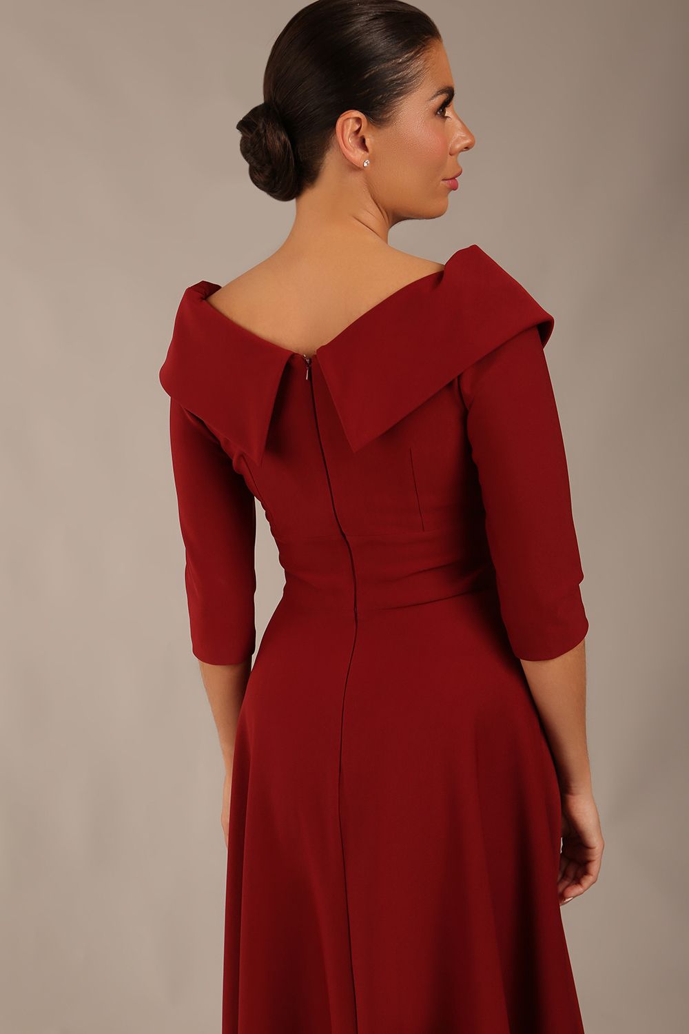 brunette model is wearing a diva catwalk Fabienne sleeved A-line Dress with pockets v neckline knee length wide waistband fold over v neckline in burgundy colour back image