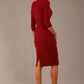 brunette model is wearing a diva catwalk Mirabelle ¾ Sleeves & Floral Shoulder Detail Pencil Dress with diagonal pleating across the front knee length in rosewood red colour back image