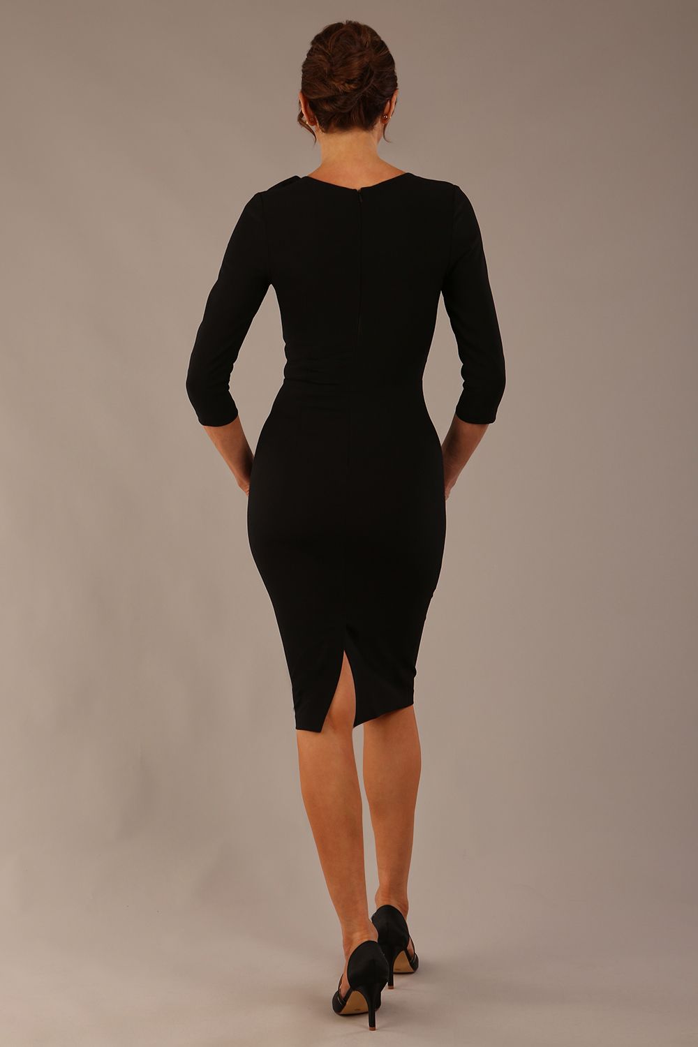 brunette model is wearing a diva catwalk Mirabelle ¾ Sleeves & Floral Shoulder Detail Pencil Dress with diagonal pleating across the front knee length in black colour back image