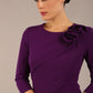 brunette model is wearing a diva catwalk Mirabelle ¾ Sleeves & Floral Shoulder Detail Pencil Dress with diagonal pleating across the front knee length in purple colour front image close up