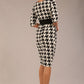 brunette model is wearing a diva catwalk OP-ART V-Neck Sleeved Monochrome Pencil Dress with black waistband and flower detail in a Super stretch dogtooth fabric black and white print front image