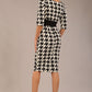 brunette model is wearing a diva catwalk OP-ART V-Neck Sleeved Monochrome Pencil Dress with black waistband and flower detail in a Super stretch dogtooth fabric black and white print front image
