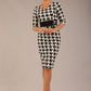 brunette model is wearing a diva catwalk OP-ART V-Neck Sleeved Monochrome Pencil Dress with black waistband and flower detail in a Super stretch dogtooth fabric black and white print front image