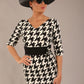 brunette model is wearing a diva catwalk OP-ART V-Neck Sleeved Monochrome Pencil Dress with black waistband and flower detail in a Super stretch dogtooth fabric black and white print front image with hat and sunglasses