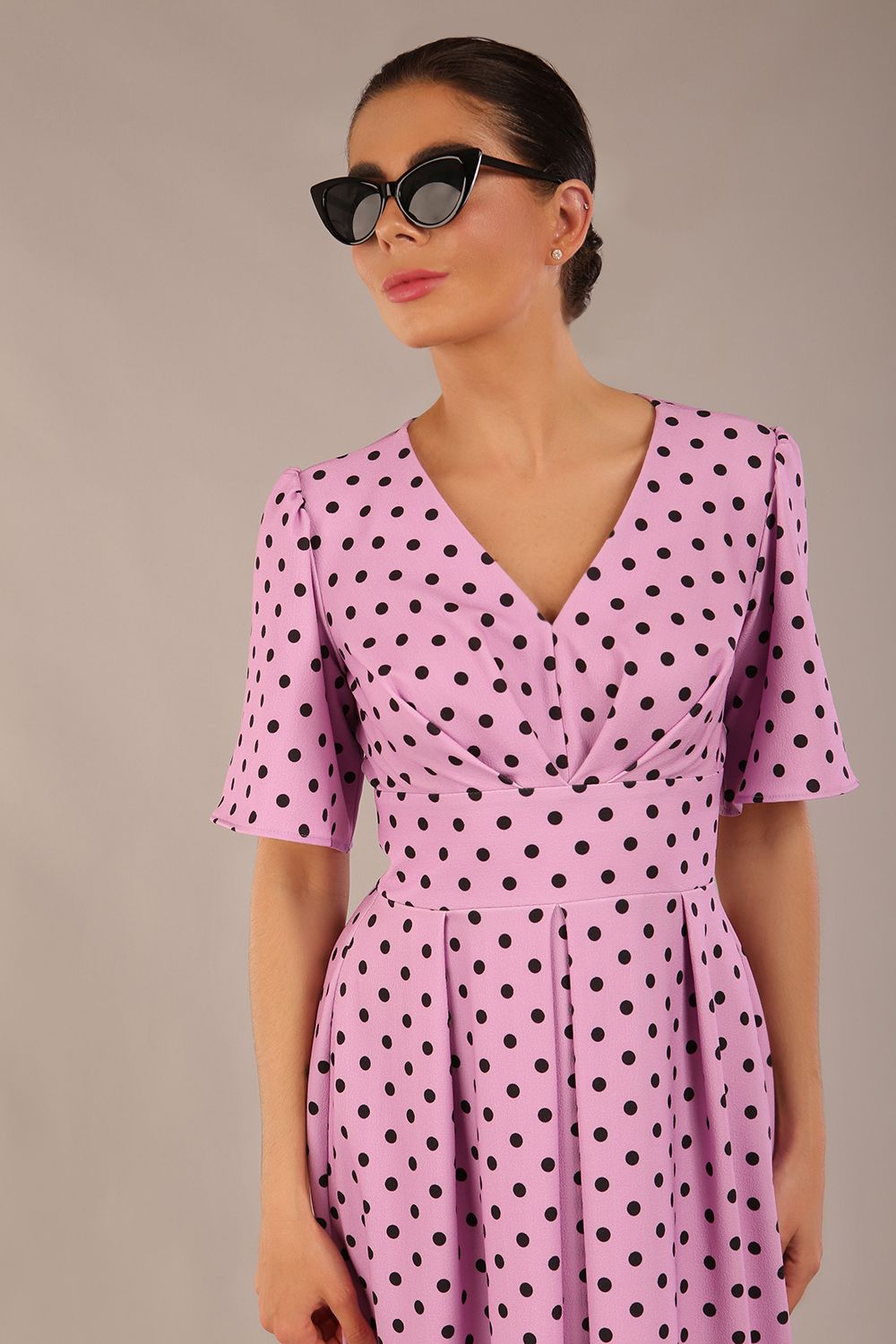 brunette model is wearing a diva catwalk Myriad Polka Dot V Neck & Bat Sleeves Midi Dress in orchid polka dot front image close up