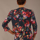 Back view of the Model wearing the Valetta cropped floral jacquard jacket over a matching dress with a plain background (Hidcote Floral)