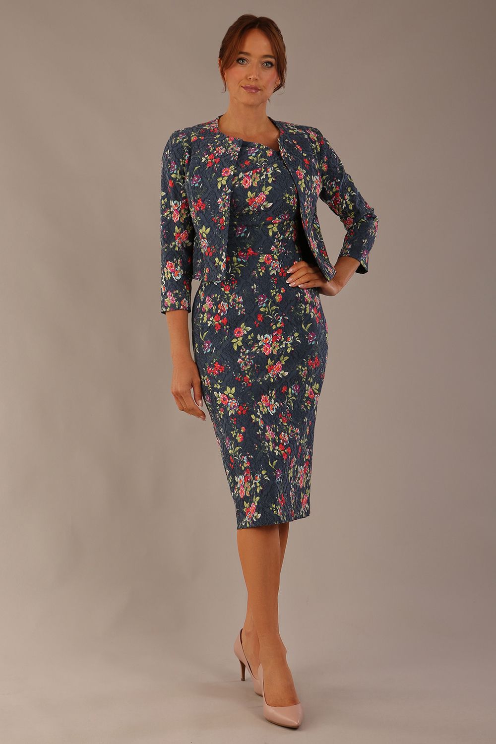 Model wearing the Valetta cropped floral jacquard jacket over a matching dress with a plain background (Navy Floral)
