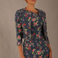 Model wearing the Valetta cropped floral jacquard jacket over a matching dress with a plain background (Navy Floral)