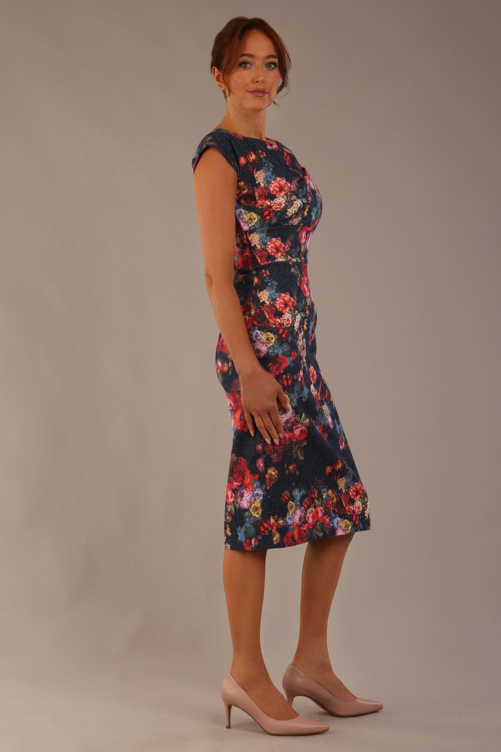 Model wearing the Nora asymmetric floral jacquard dress, showcasing the unique draped neckline (Hidcote Floral)