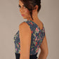brunette model is wearing a diva catwalk June Floral Sleeveless Navy Waistband Pencil Dress in floral blue print back image close up