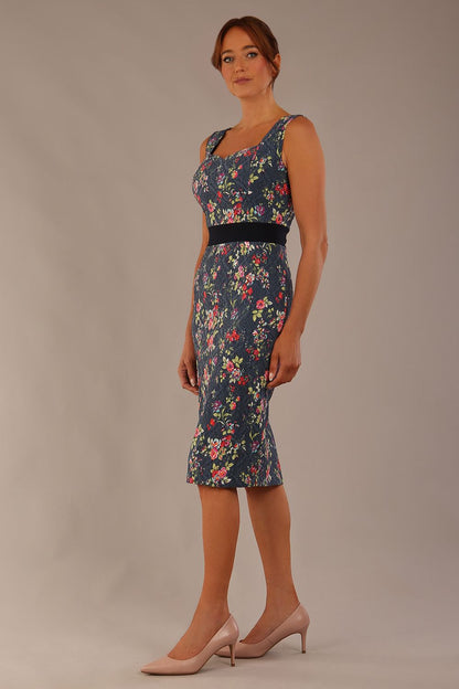 brunette model is wearing a diva catwalk June Floral Sleeveless Navy Waistband Pencil Dress in floral blue print front image
