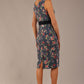 brunette model is wearing a diva catwalk June Floral Sleeveless Navy Waistband Pencil Dress in floral blue print back image