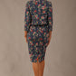 brunette model is wearing a diva catwalk June Floral Sleeveless Navy Waistband Pencil Dress in floral blue print back image with valetta jacket