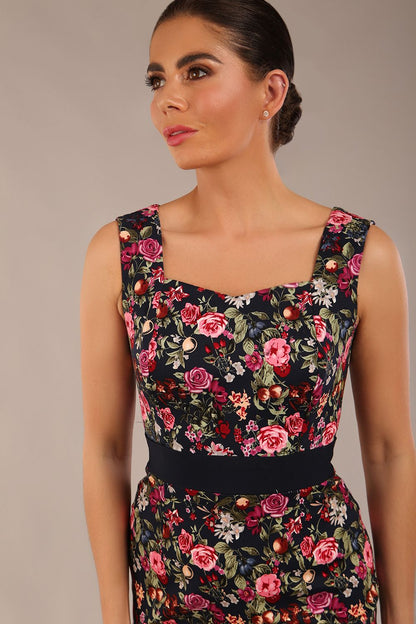brunette model is wearing a diva catwalk June Floral Sleeveless Navy Waistband Pencil Dress in Navy Spring Rose front image close up
