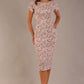 brunette model is wearing a 7002 diva catwalk Carlisle Boat Neck Short Sleeve Midi Pencil Dress in Tudor Vine print with side pockets front