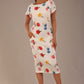 brunette model is wearing a 7002 diva catwalk Carlisle Boat Neck Short Sleeve Midi Pencil Dress in Buttercup print with side pockets front