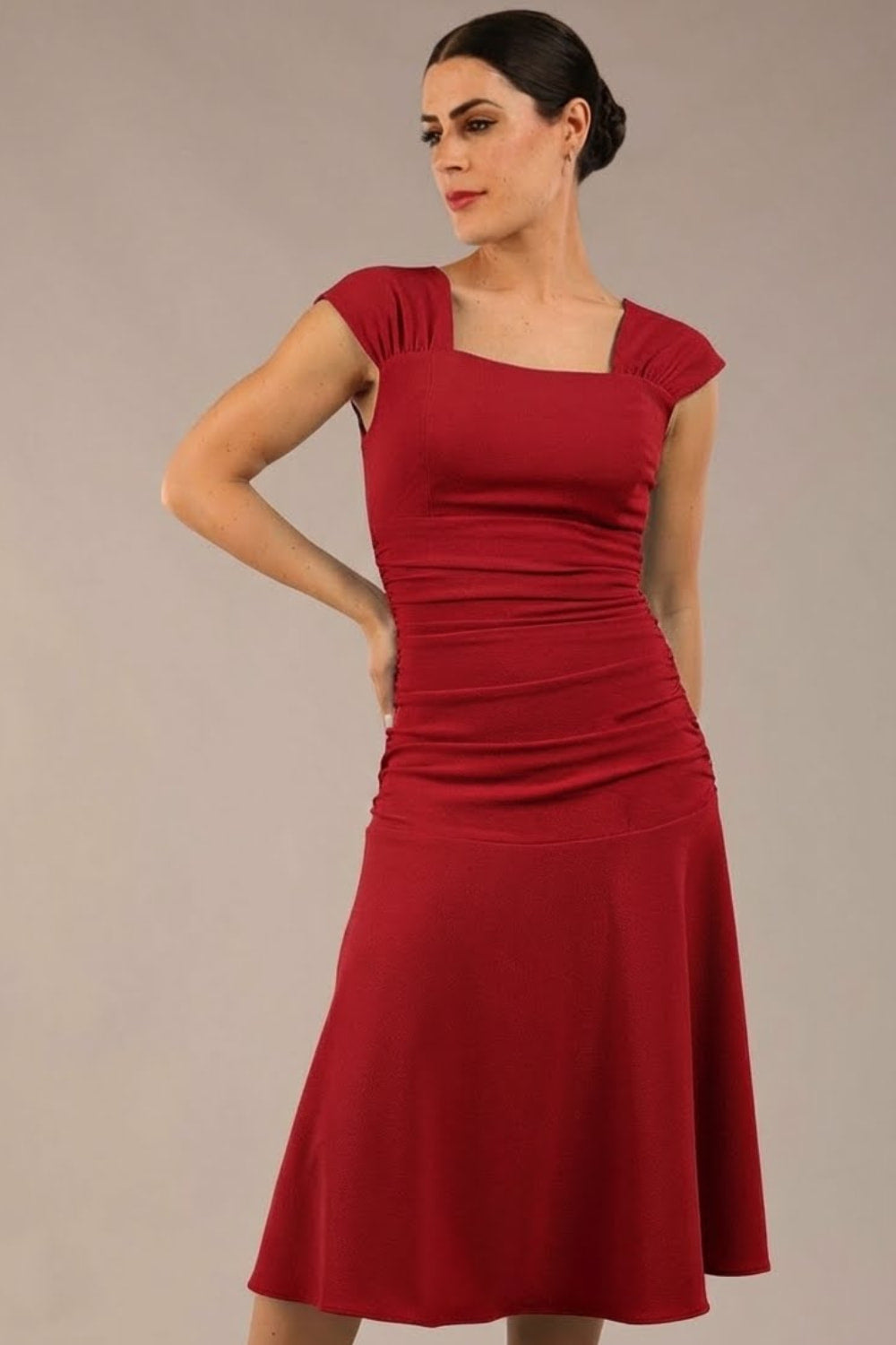 brunette model is wearing a diva catwalk Sonning Cap Sleeve Square Neckline A-Line midi Dress and rushing side details in Passion Red colour front (Passion Red)