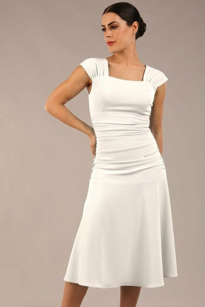 brunette model is wearing a diva catwalk Sonning Cap Sleeve Square Neckline A-Line midi Dress and rushing side details in Ivory Cream colour front (Ivory Cream)
