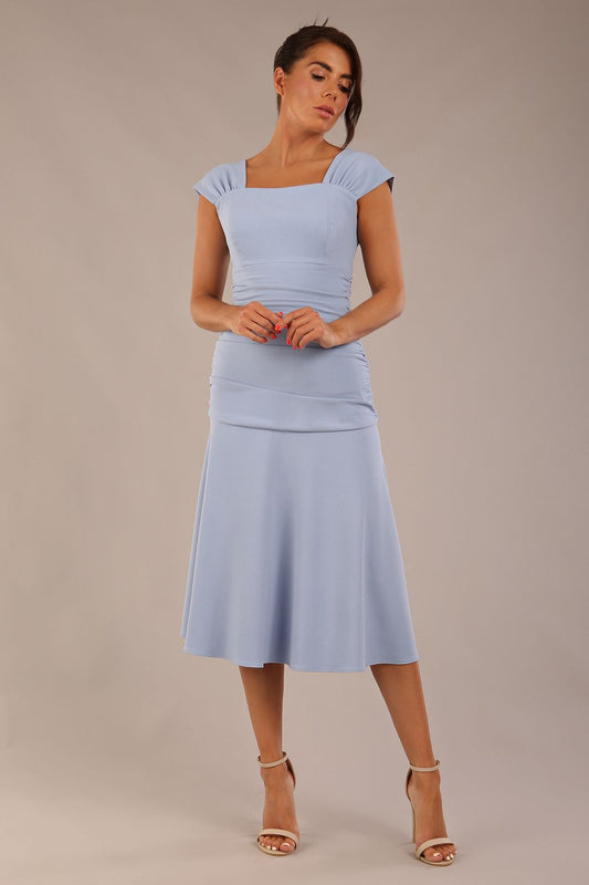 brunette model is wearing a diva catwalk Sonning Cap Sleeve Square Neckline A-Line midi Dress and rushing side details in powder blue colour front
