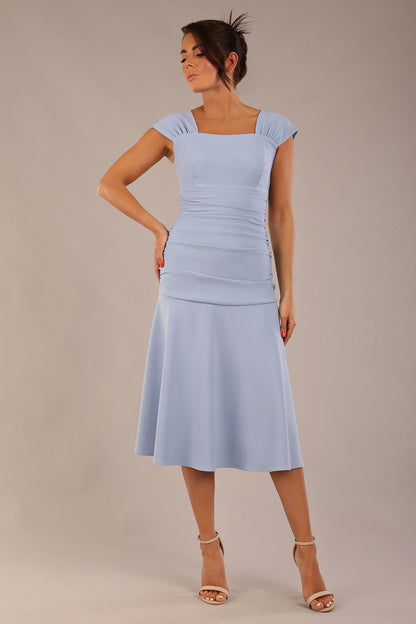 brunette model is wearing a diva catwalk Sonning Cap Sleeve Square Neckline A-Line midi Dress and rushing side details in powder blue colour front