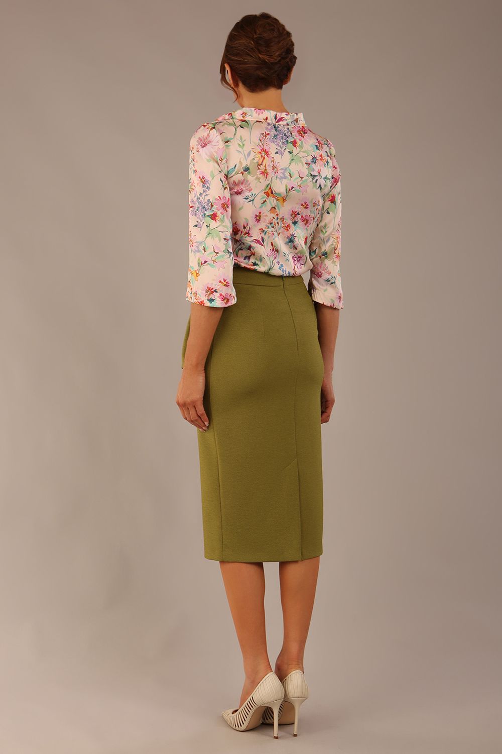 Model wearing the Rockwell 3/4 sleeve satin top in Lush Garden print, styled with an olive green pencil skirt.