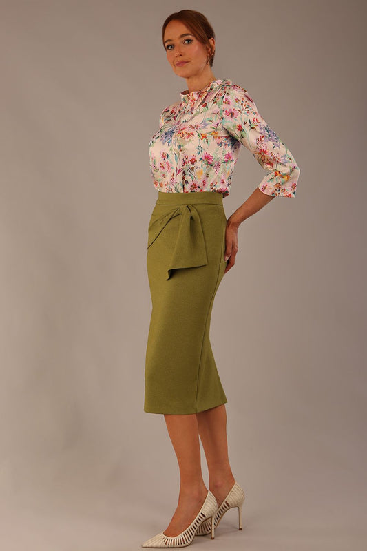 Model wearing the Rockwell 3/4 sleeve satin top in Lush Garden print, styled with an olive green pencil skirt.