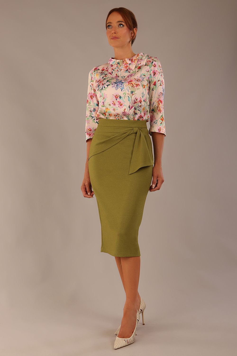 Model wearing the Rockwell 3/4 sleeve satin top in Lush Garden print, styled with an olive green pencil skirt.