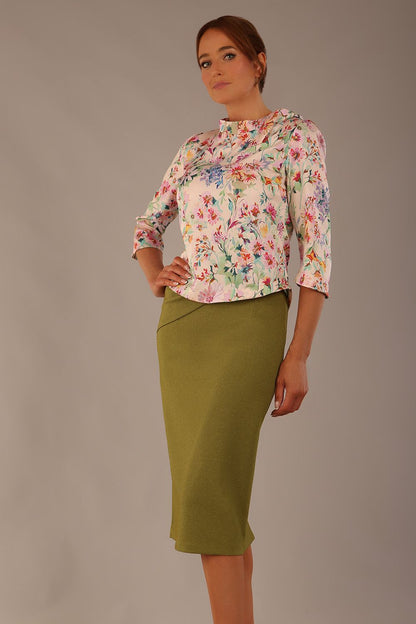 Model wearing the Rockwell 3/4 sleeve satin top in Lush Garden print, styled with an olive green pencil skirt.