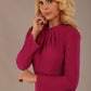 Close-up of the elegant pleated high neckline on the Remy dress in festive fuchsia.