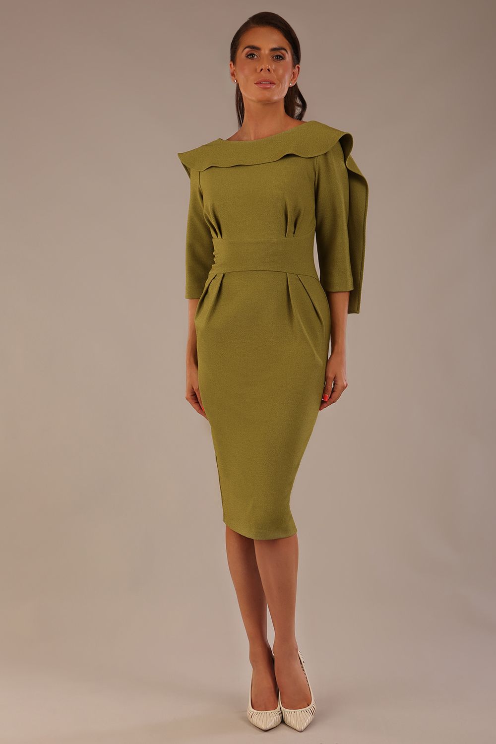 Model wearing the Rio statement collar pencil dress in oasis green, showcasing its architectural silhouette.