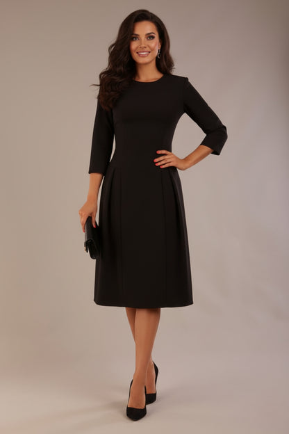 Model wearing the Ario pleated A-line dress in black, showcasing the round neckline and 3/4 sleeves.