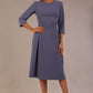 Model wearing the Ario pleated A-line dress in blue mineral, showcasing the round neckline and 3/4 sleeves.