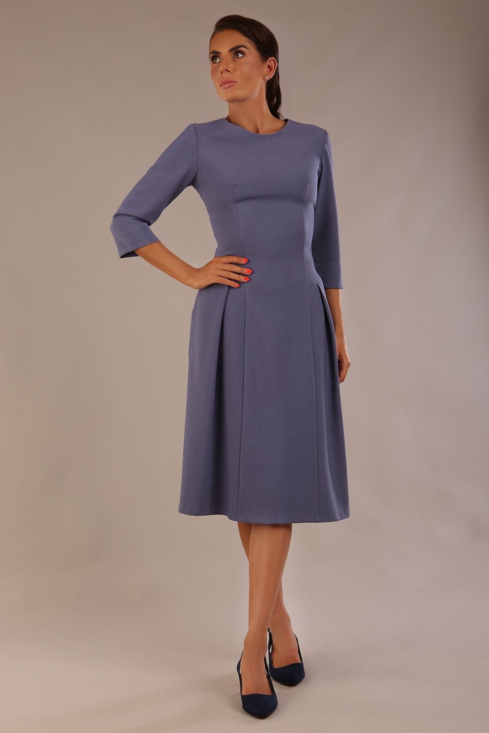 Model wearing the Ario pleated A-line dress in blue mineral, showcasing the round neckline and 3/4 sleeves.
