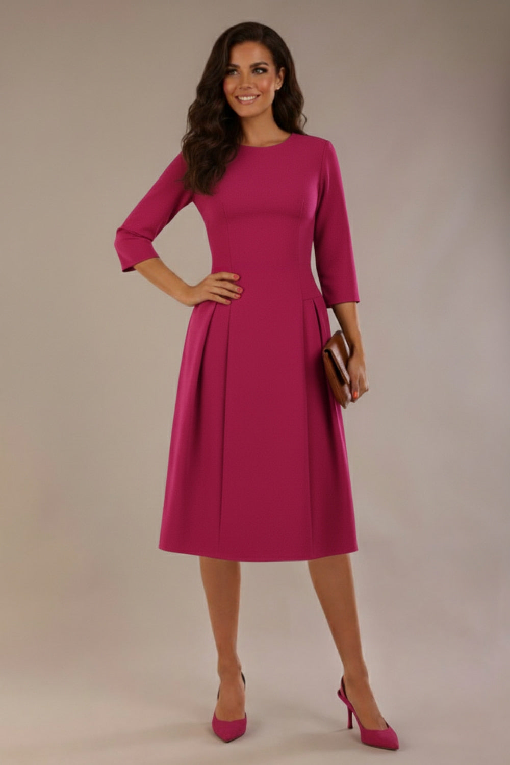 Model wearing the Ario pleated A-line dress in festive fuchsia, showcasing the round neckline and 3/4 sleeves