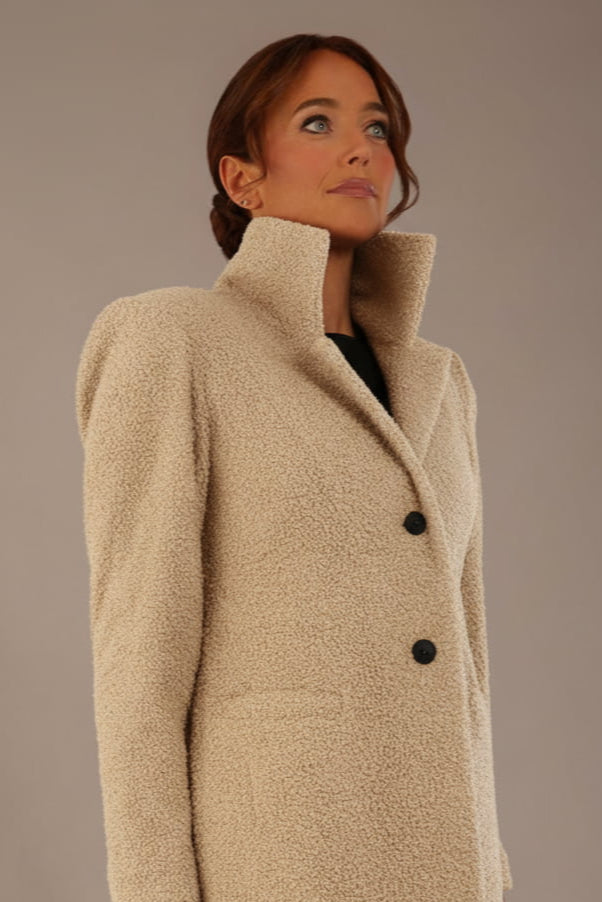 Model wearing the Ambrose boucle midi coat in pink tint, long sleeves teddy feeling with a collar neckline and 2 closure buttons at the front and pockets close up