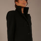 Model wearing the Ambrose boucle midi coat in black, long sleeves teddy feeling with a collar neckline and 2 closure buttons at the front and pockets close up