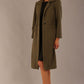 Model wearing the Ambrose boucle midi coat in olive green, long sleeves teddy feeling with a collar neckline and 2 closure buttons at the front and pockets