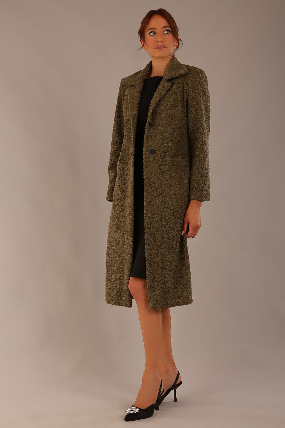 Model wearing the Ambrose boucle midi coat in olive green, long sleeves teddy feeling with a collar neckline and 2 closure buttons at the front and pockets