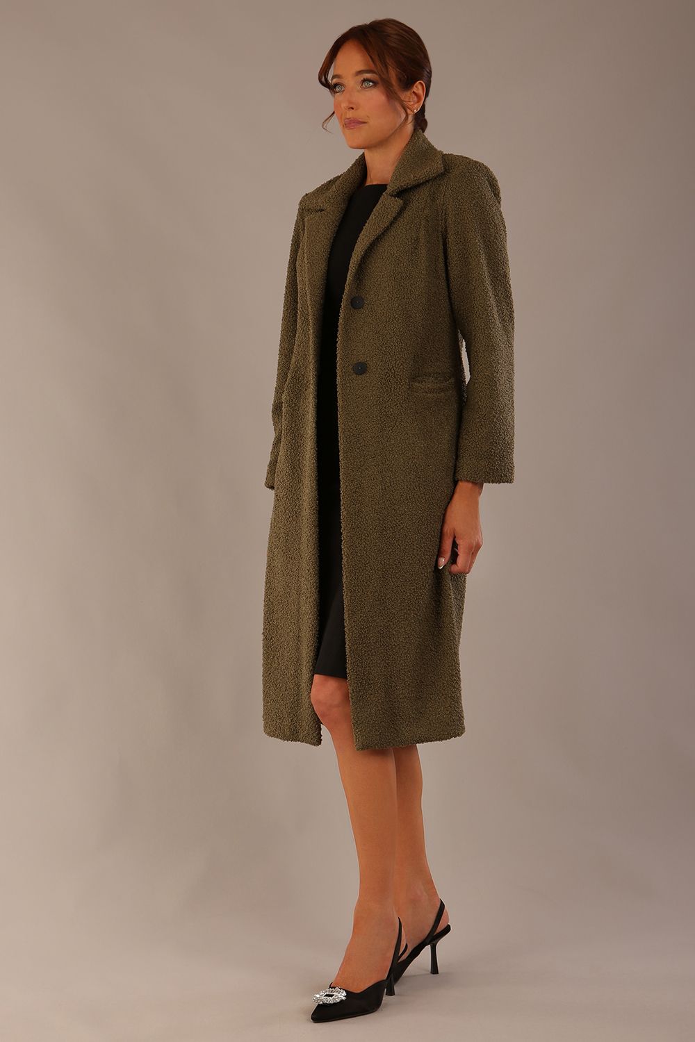 Model wearing the Ambrose boucle midi coat in olive green, long sleeves teddy feeling with a collar neckline and 2 closure buttons at the front and pockets