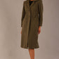 Model wearing the Ambrose boucle midi coat in olive green, long sleeves teddy feeling with a collar neckline and 2 closure buttons at the front and pockets