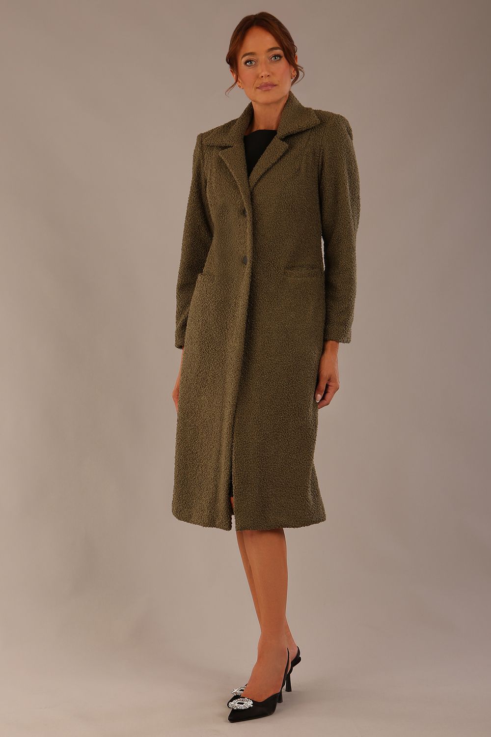 Model wearing the Ambrose boucle midi coat in olive green, long sleeves teddy feeling with a collar neckline and 2 closure buttons at the front and pockets