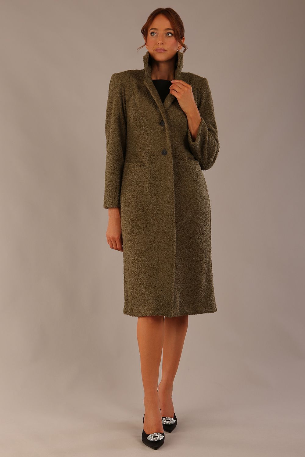 Model wearing the Ambrose boucle midi coat in olive green, long sleeves teddy feeling with a collar neckline and 2 closure buttons at the front and pockets