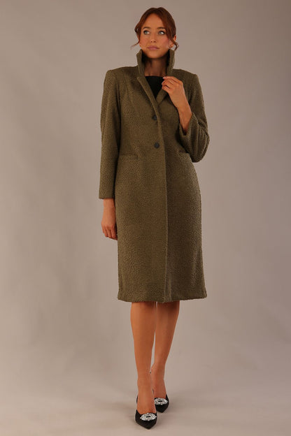 Model wearing the Ambrose boucle midi coat in olive green, long sleeves teddy feeling with a collar neckline and 2 closure buttons at the front and pockets