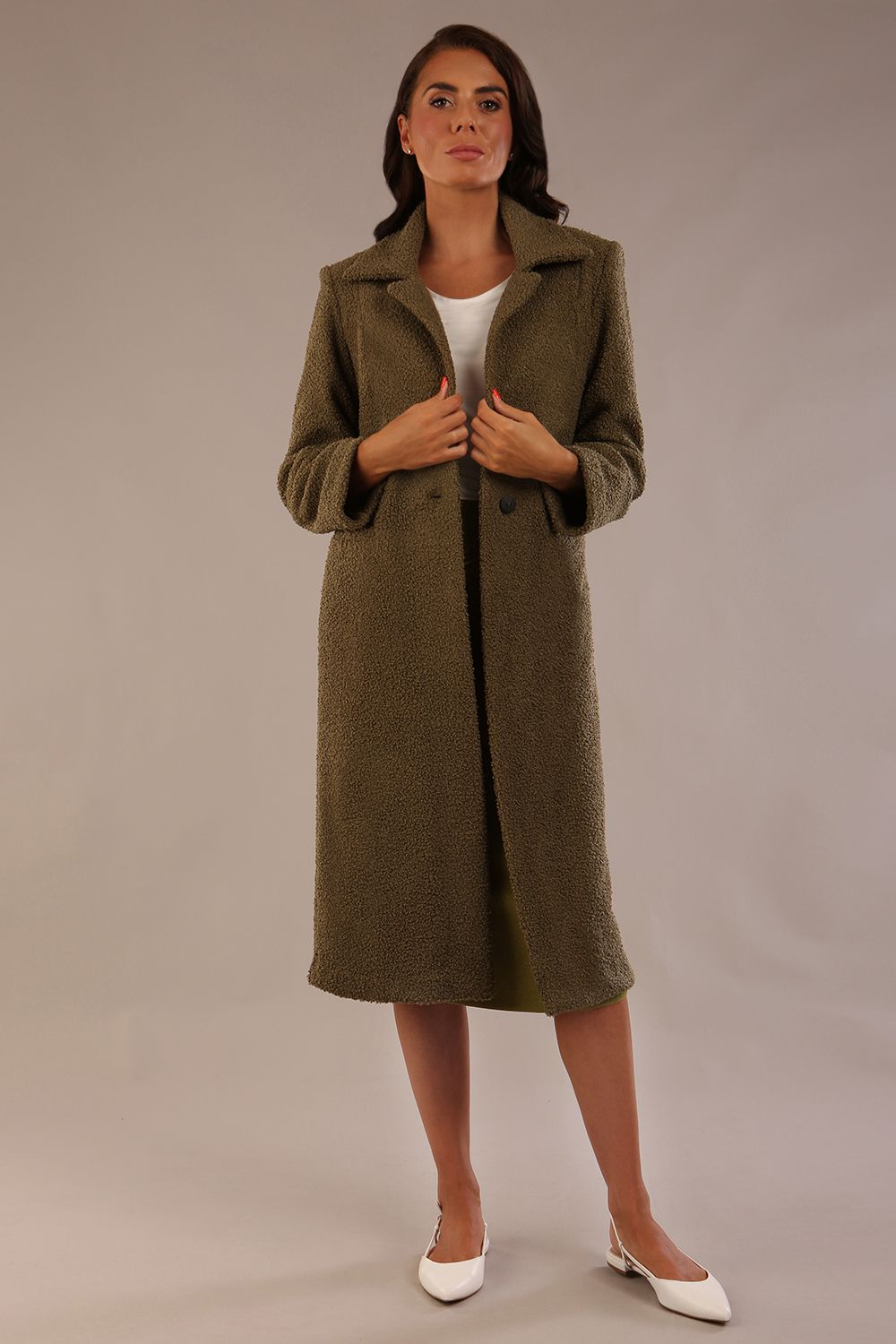 Model wearing the Ambrose boucle midi coat in olive green, long sleeves teddy feeling with a collar neckline and 2 closure buttons at the front