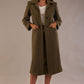 Model wearing the Ambrose boucle midi coat in olive green with hands in the side pockets.