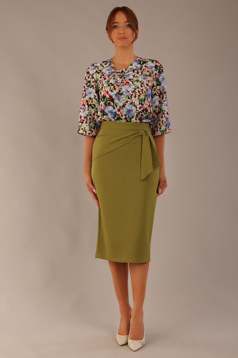 Model wearing an Oasis Green Hedy pencil skirt with a draped front and a sophisticated floral top