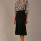 Model wearing a Suki asymmetric draped top in the Aurora Botanical print, styled with a black fishtail skirt.