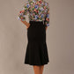 Model wearing a Suki asymmetric draped top in the Aurora Botanical print, styled with a black fishtail skirt.