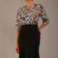 Model wearing a Suki asymmetric draped top in the Aurora Botanical print, styled with a black fishtail skirt.